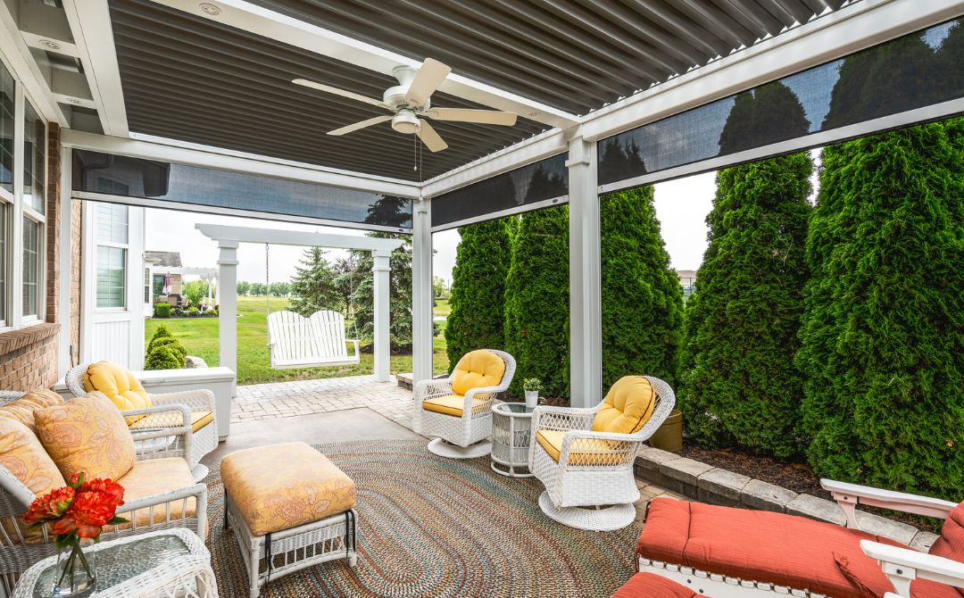 a patio with chairs and a fan under modern pergolas