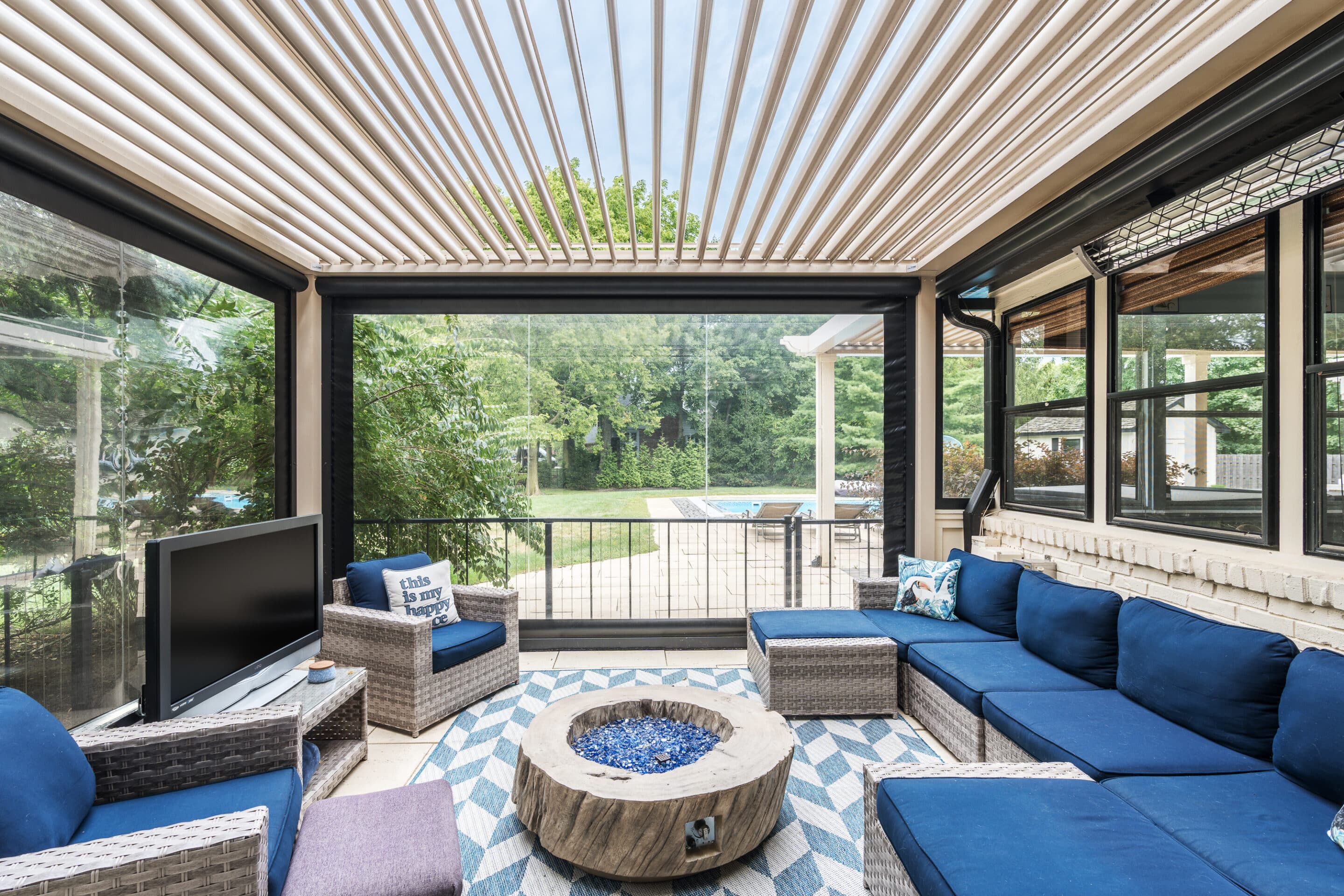 Example of how louvered roof systems add value to a residential home by expanding an outdoor living space with retractable screens and heating.